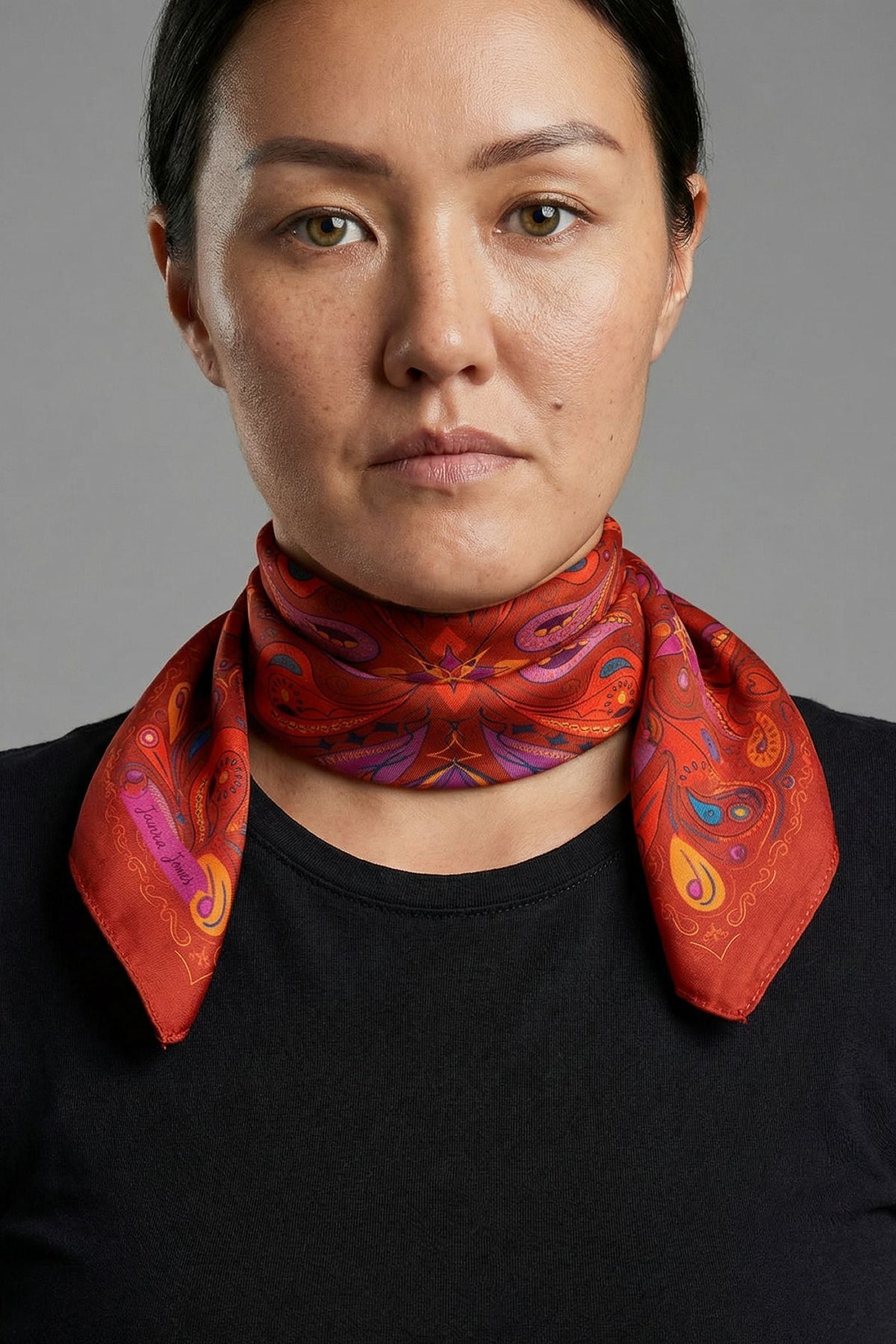 Red satin twill scarf with symmetrical paisley print in purple, yellow and blue accents