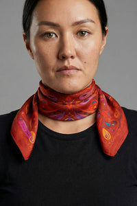 Red satin twill scarf with symmetrical paisley print in purple, yellow and blue accents